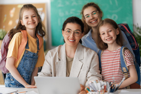 Happy kids and teacher at school. Woman and children are working in the class.の写真素材