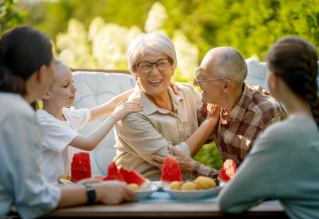 Happy family spending time together in summer morning. Family sitting in the garden and enjoying the conversation.の写真素材