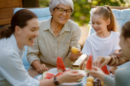 Happy family spending time together in summer morning. Family sitting in the garden and enjoying the...