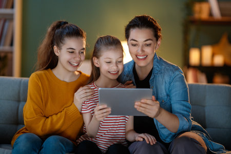 Smiling family using tablet pc together sitting on the sofa at home.の写真素材