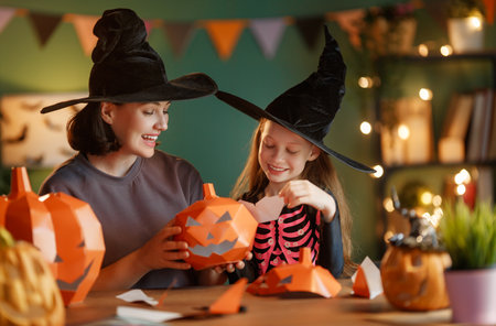 Happy family preparing for Halloween. Mother and child cutting pumpkins at home.の写真素材