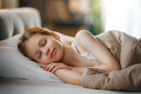 Adorable little girl is sleeping in the bed at home.の写真素材