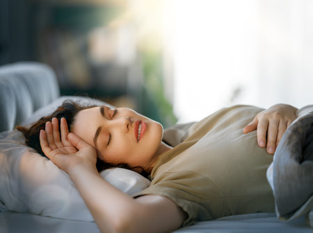 A beautiful young woman is sleeping in the bedroom at home.の写真素材