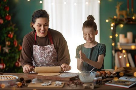 Merry Christmas and Happy Holidays. Family preparation holiday food. Mother and daughter cooking cookies.の写真素材