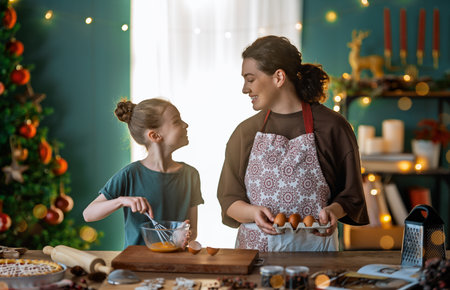 Merry Christmas and Happy Holidays. Family preparation holiday food. Mother and daughter cooking cookies.の写真素材