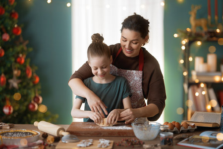 Merry Christmas and Happy Holidays. Family preparation holiday food. Mother and daughter cooking cookies.の写真素材
