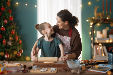 Merry Christmas and Happy Holidays. Family preparation holiday food. Mother and daughter cooking cookies.の写真素材
