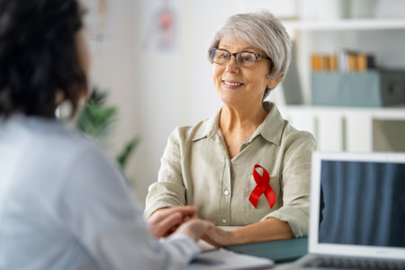 Colour ribbon for concept of illness awareness. Female patient listening to doctor in medical office. Raising knowledge on people living with disease.の写真素材