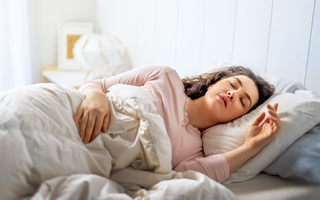 A beautiful young woman is sleeping in the bedroom at home.の写真素材