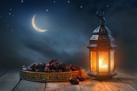 Ornamental Arabic lantern with burning candle glowing at night. Festive greeting card, invitation for Muslim holy month Ramadan Kareem.の写真素材