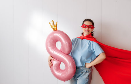 Beautiful young woman with a balloon in the shape of an eight.の写真素材