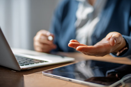 Woman is working in the office. Laptop, tablet pc and hands close up.