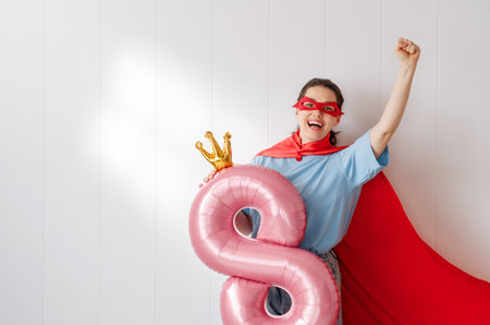 Beautiful young woman with a balloon in the shape of an eight. Concept of International Women's Day.の写真素材