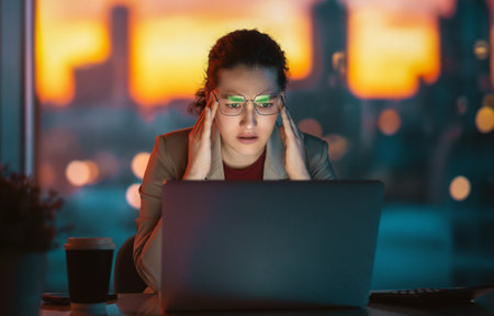 Young businesswoman working on laptop in the evening.