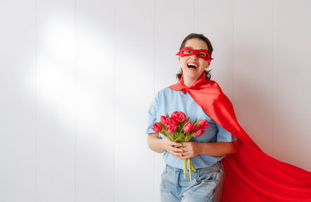 Beautiful young woman with red tulips. Concept of International Mother's Day.の写真素材