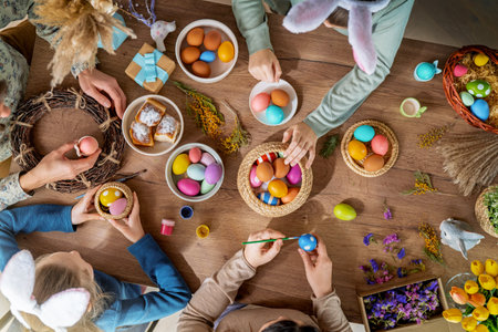 Easter holiday background. Family is painting eggs on wooden table. Top viewの写真素材