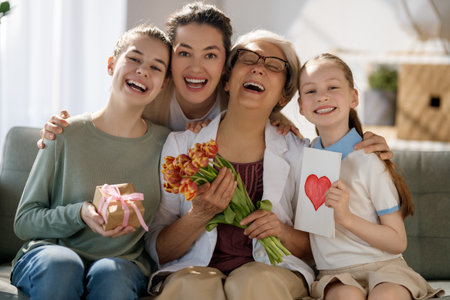 Happy mother's day! Children daughters are congratulating mom and grandma giving them flowers...