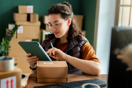 Female inventory manager checking stock. Woman working in a warehouse.の写真素材
