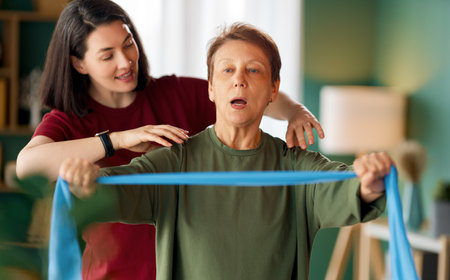 Senior woman doing exercise. A nurse helping with physical therapy at home