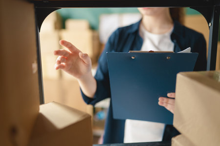 Female inventory manager checking stock. Woman working in a warehouse.