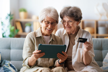 Women are doing online purchases. Senior people are doing shopping using laptop and credit card at home.の写真素材