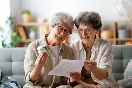 Two senior women are taking medication at home.の写真素材