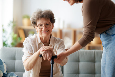 Happy patient and caregiver spending time together. Senior woman holding cane.の写真素材