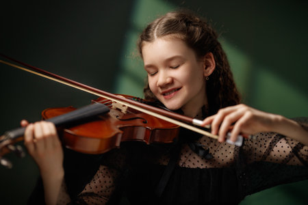 Young girl in black dress playing violin
