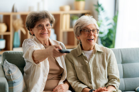 Senior women watching TV, movies. Retirees spending time at home.の写真素材