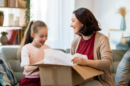 Mother and daughter are unpacking cardboard. Concept of online shopping.の写真素材