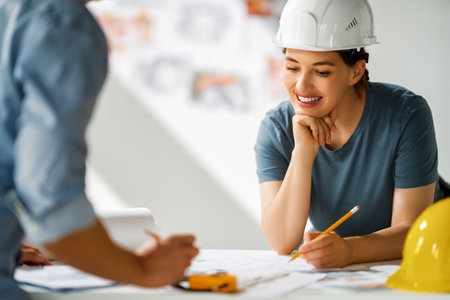 Team of architects working on plans at construction site.の写真素材