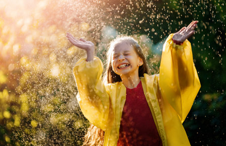 Happy little girl in the rain on an autumn walkの写真素材