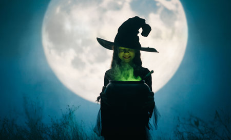 Girl dressed in witch costumes for Halloween. Kid standing on full moon background.の写真素材