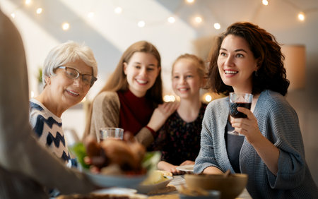 Thanksgiving Day, Autumn feast. Happy family sitting at the table and celebrating holiday. Traditional dinner. Grandmother and granddaughters.の写真素材