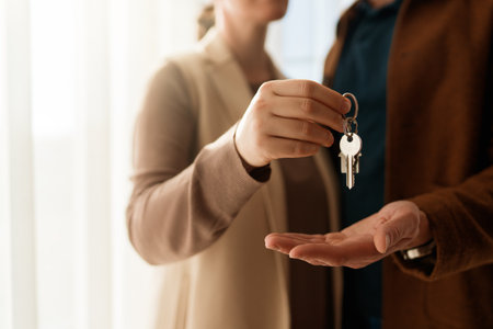 Real estate agent gives house keys to new homeowner. Property deal, mortgage loanの写真素材