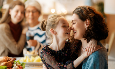 Thanksgiving Day, Autumn feast. Happy family sitting at the table and celebrating holiday. Traditional dinner. Grandmother and granddaughters.の写真素材