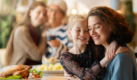Thanksgiving Day, Autumn feast. Happy family sitting at the table and celebrating holiday. Traditional dinner. Grandmother and granddaughters.の写真素材