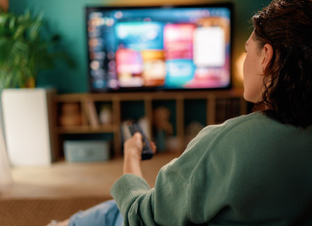 Happy woman watching TV at home.