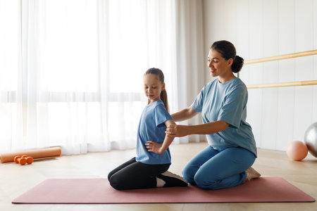 The child is undergoing physical therapy. The girl is doing exercises under the doctor's supervision.の写真素材