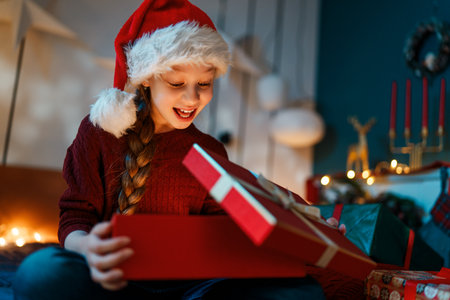 Merry Christmas and Happy Holidays. Cheerful cute child girl with gift. Kid is having fun.の写真素材