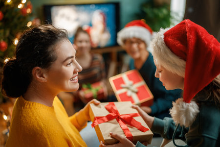 Merry Christmas and Happy Holidays. Grandma, mum and children exchanging gifts. Parents and daughters having fun near tree indoors. Loving family with presents in room.の写真素材