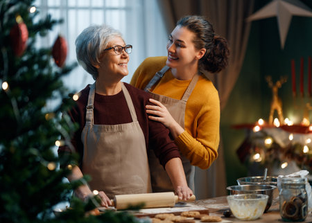 Merry Christmas and Happy Holidays. Family preparation holiday food. Mother and her adult daughter cooking cookies.の写真素材