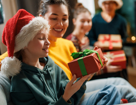 Merry Christmas and Happy Holidays. Grandma, mum and children exchanging gifts. Parents and daughters having fun indoors. Loving family with presents in room.の写真素材
