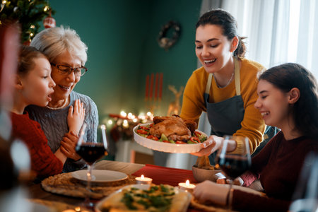 Merry Christmas. Happy family are having dinner at home. Celebration holiday and togetherness near tree.の写真素材