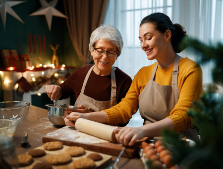 Merry Christmas and Happy Holidays. Family preparation holiday food. Mother and her adult daughter cooking cookies.の写真素材