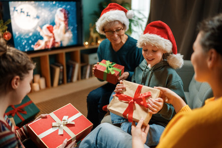 Merry Christmas and Happy Holidays. Grandma, mum and children exchanging gifts. Parents and daughters having fun indoors. Loving family with presents in room.の写真素材