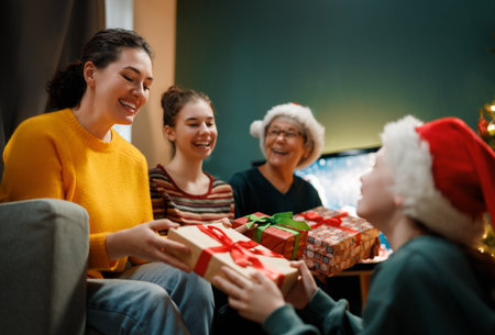 Merry Christmas and Happy Holidays. Grandma, mum and children exchanging gifts. Parents and daughters having fun indoors. Loving family with presents in room.の写真素材