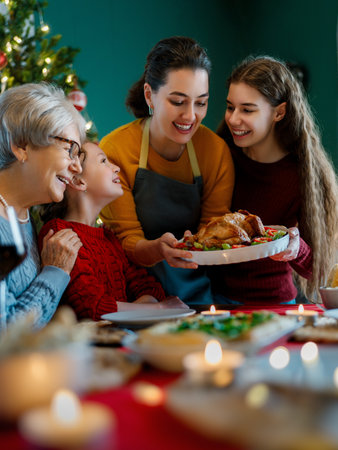 Merry Christmas. Happy family are having dinner at home. Celebration holiday and togetherness near tree.の写真素材