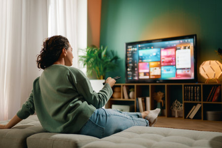 Happy woman watching TV at home.
