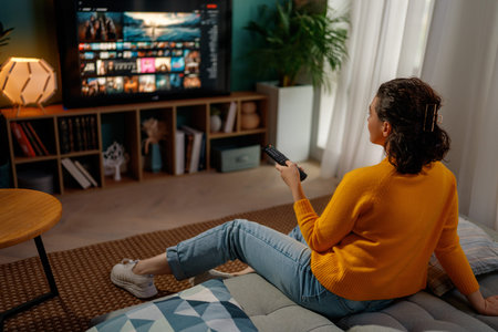 Happy woman watching TV at home.